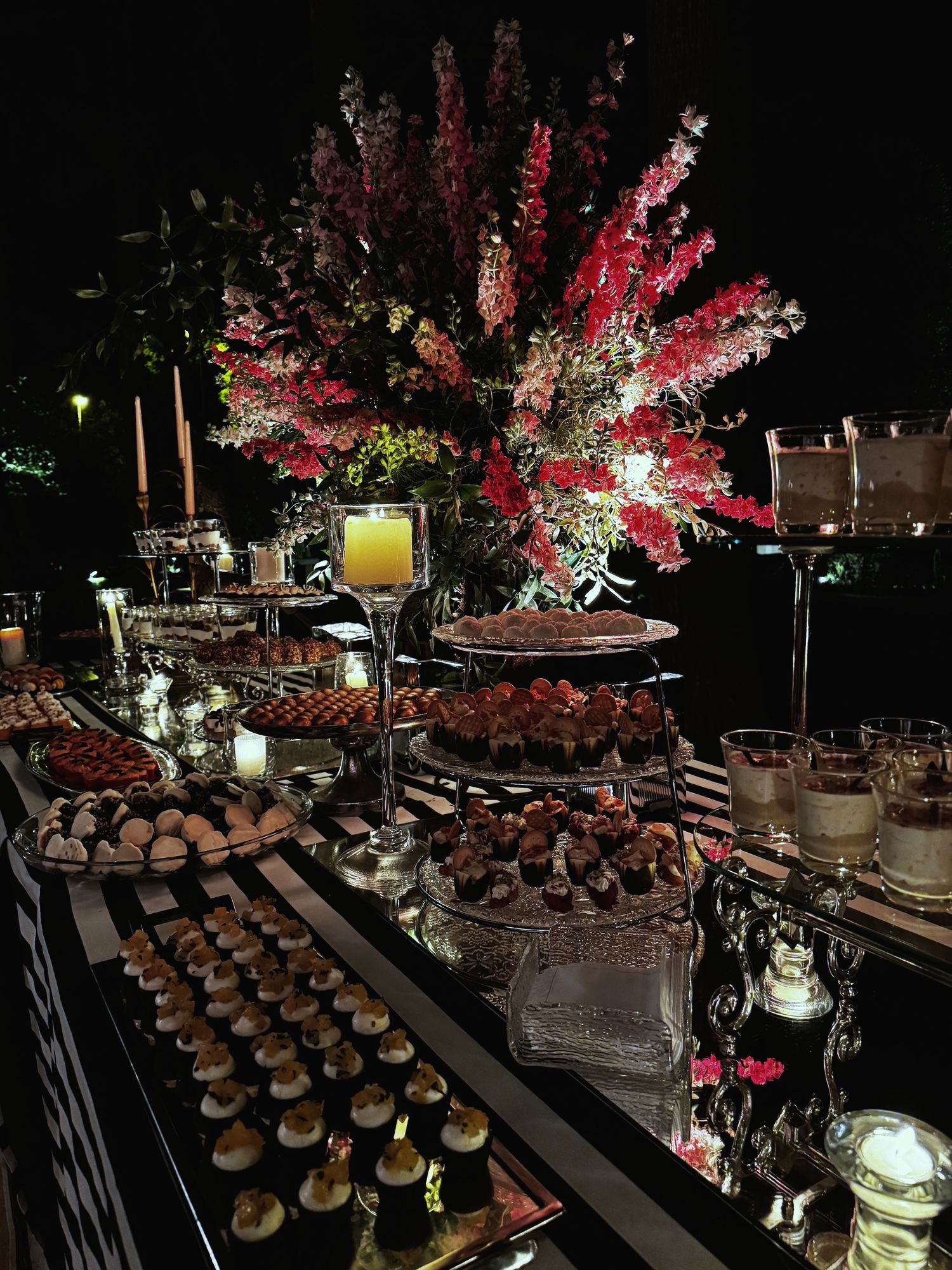 Evening dessert table with a grand floral arrangement
